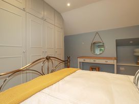 A bedroom with a bed, wardrobe, and dressing table at Seveock in Threemilestone