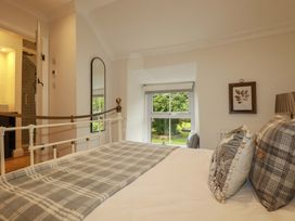 A bedroom with a bed and window overlooking greenery at Seveock Threemilestone