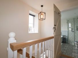 A hallway with a staircase and a bathroom entrance at Seveock in Threemilestone