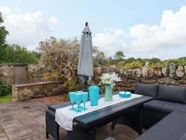 A patio with a table and seating area at Seveock in Threemilestone