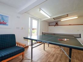 A games room with a ping pong table and seating at Seveock in Threemilestone