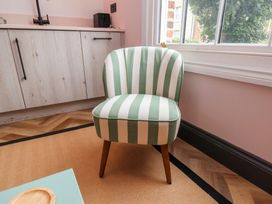 A striped chair near a kitchen unit and window at Apartment Pink