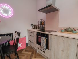 A kitchen with stove, sink, and teapot at Apartment Pink