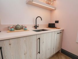 A kitchen with a sink, cabinets, kettle, tea cups, toaster at Apartment Pink