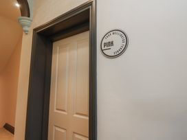 A door with a sign for Apartment Pink at Four Wellington Terrace