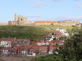 A view of the abbey ruins and houses on a hill at Apartment Pink in Whitby