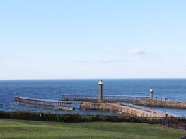 A view of a pier extending into the sea at Apartment Pink in Whitby