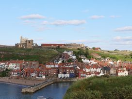 A coastal village with houses near the water and castle ruins in Whitby