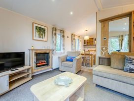 A living room with a television and fireplace at Bingos Cabin in Holt