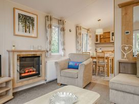 A living room with a sofa and dining table at Bingos Cabin in Holt