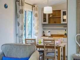 A dining room with a table and chairs at Bingos Cabin in Holt