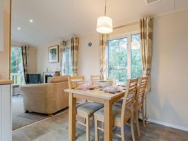 A dining room with a table and chairs at Bingos Cabin in Holt
