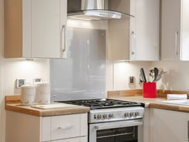 A kitchen with a stove and cabinets at Bingos Cabin in Holt