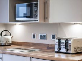 A kitchen with a microwave kettle and toaster at Bingos Cabin in Holt