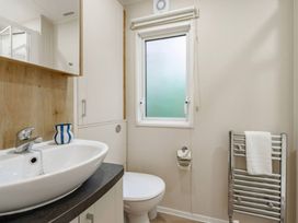 A bathroom with sink and toilet at Bingos Cabin in Holt