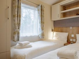 A bedroom with two beds and a window at Bingos Cabin in Holt