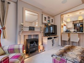 A living room with a fireplace and television at Four Seasons in Holt