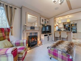 A living room with a television and fireplace at Four Seasons in Holt