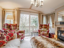 A living room with armchairs and a fireplace at Four Seasons in Holt