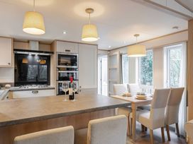 A kitchen with a dining table and wine glasses at Four Seasons in Holt