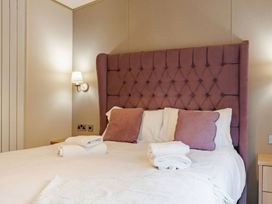 A bedroom with a bed and bedside table at Four Seasons in Holt