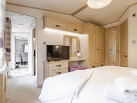 A bedroom with a bed and television at Four Seasons in Holt