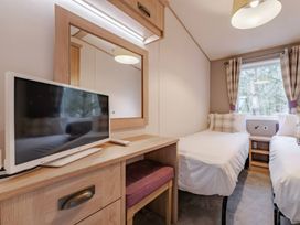 A bedroom with a television and two beds at Four Seasons, Holt