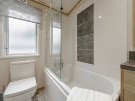 A bathroom with a bathtub and toilet at Four Seasons in Holt
