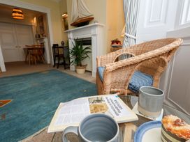 A living room with a chair, table, and plant at No 3 By The Sea, Weymouth