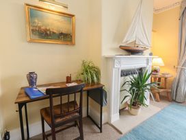 A living room with a desk and a model boat at No 3 By The Sea in Weymouth