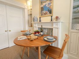 A dining room with a table set and fruit at No 3 By The Sea Weymouth