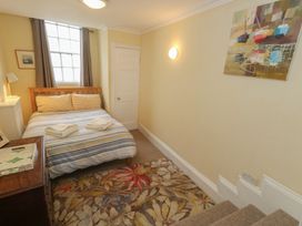 A bedroom with a bed and a painting at No 3 By The Sea Weymouth