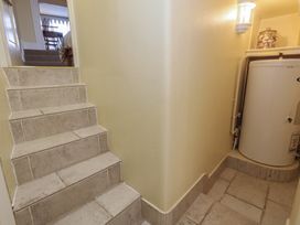 A hallway with stairs leading up and a water heater at No 3 By The Sea in Weymouth