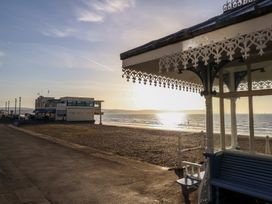 A beach scene with a building and a bench at Number 3 by the Sea Weymouth