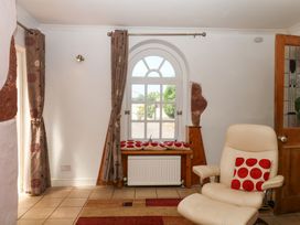 A sitting room with a chair and window at Gorway Cottage in Teignmouth