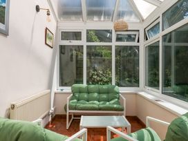 A conservatory with seating and a coffee table at Gorway Cottage in Teignmouth