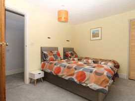 A bedroom with two beds and a nightstand at Gorway Cottage in Teignmouth