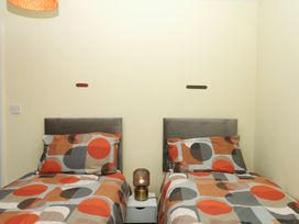 A bedroom with two single beds and a bedside table at Gorway Cottage Teignmouth