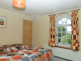 A bedroom with two beds and a window at Gorway Cottage in Teignmouth