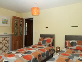A bedroom with two beds and a lamp at Gorway Cottage Teignmouth