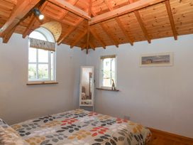 A bedroom with a bed and a mirror at Gorway Cottage in Teignmouth