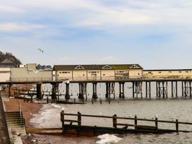 A pier with buildings above water in Teignmouth at Gorway Cottage