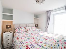 A bedroom with a bed and nightstand at Swallow Cottage in Sheviock near Crafthole