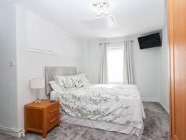 A bedroom with a bed and nightstand at Swallow Cottage in Sheviock near Crafthole