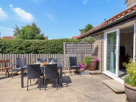 An outdoor patio area with a table and chairs at Wheeldale Cottage in Goathland