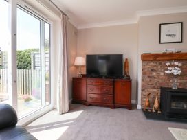 A living room with a television and cabinets at Wheeldale Cottage in Goathland