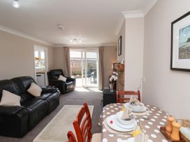 A living room with a sofa and dining area at Wheeldale Cottage in Goathland
