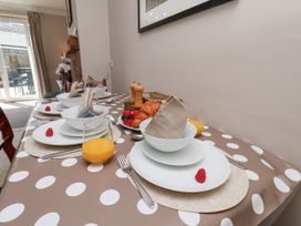 A dining room table set with plates and glasses at Wheeldale Cottage in Goathland