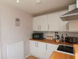 A kitchen with appliances and cabinets at Wheeldale Cottage in Goathland