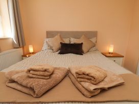 A bedroom featuring a bed with linens and towels at Wheeldale Cottage in Goathland